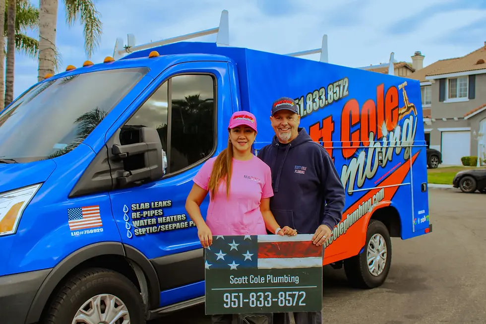 Scott Cole with his wife holding up sign to contact Scott Cole Plumbing
