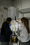Plumber performing a water heater inspection with a customer