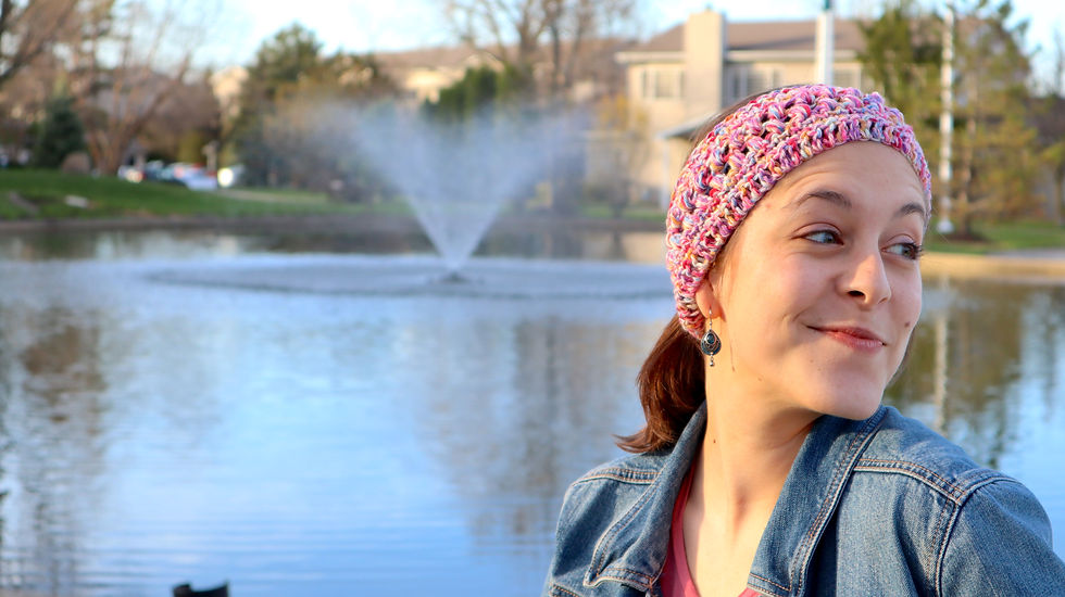 Hip girl wearing a handmade crocheted head wrap in the spring time.