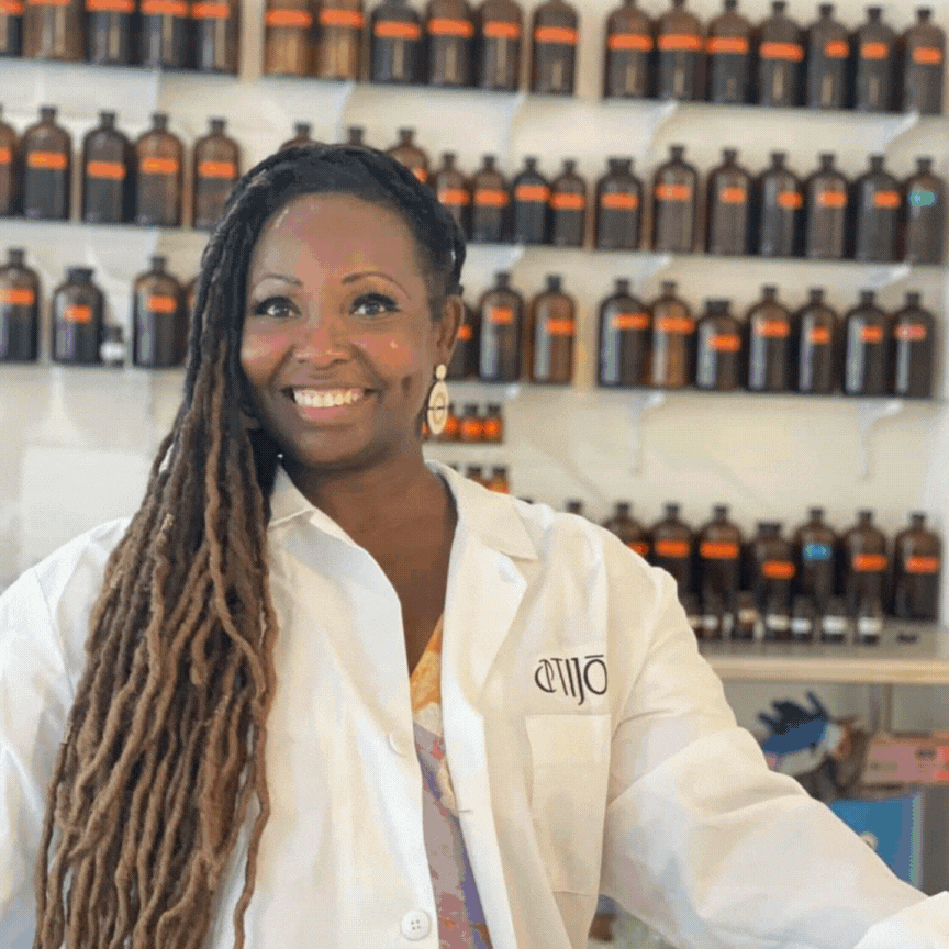 Judith Rapley in a lab coat showing the process of creating the Pure Joie fragrance