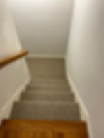 Carpeted staircase with wooden rail, part of interior design portfolio.