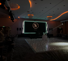 Elegant event hall with glowing dance floor and screen
