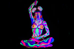Neon body paint with glowing accessories in UV light with lots of eyes.