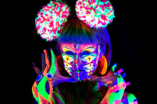 Neon body paint with glowing accessories in UV light with lots of eyes.