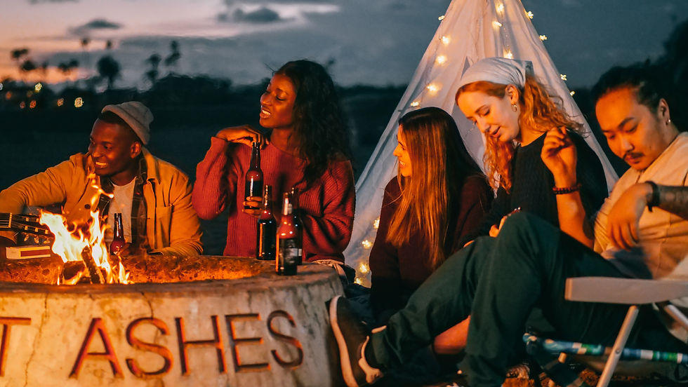 An outside fire pit heating up a group of friends as they drink beer.