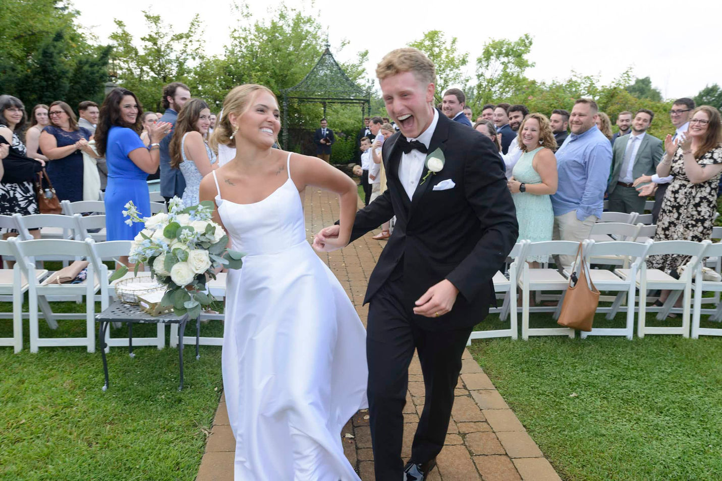 Bride and groom smiling and walking down the aisle after ceremony.
