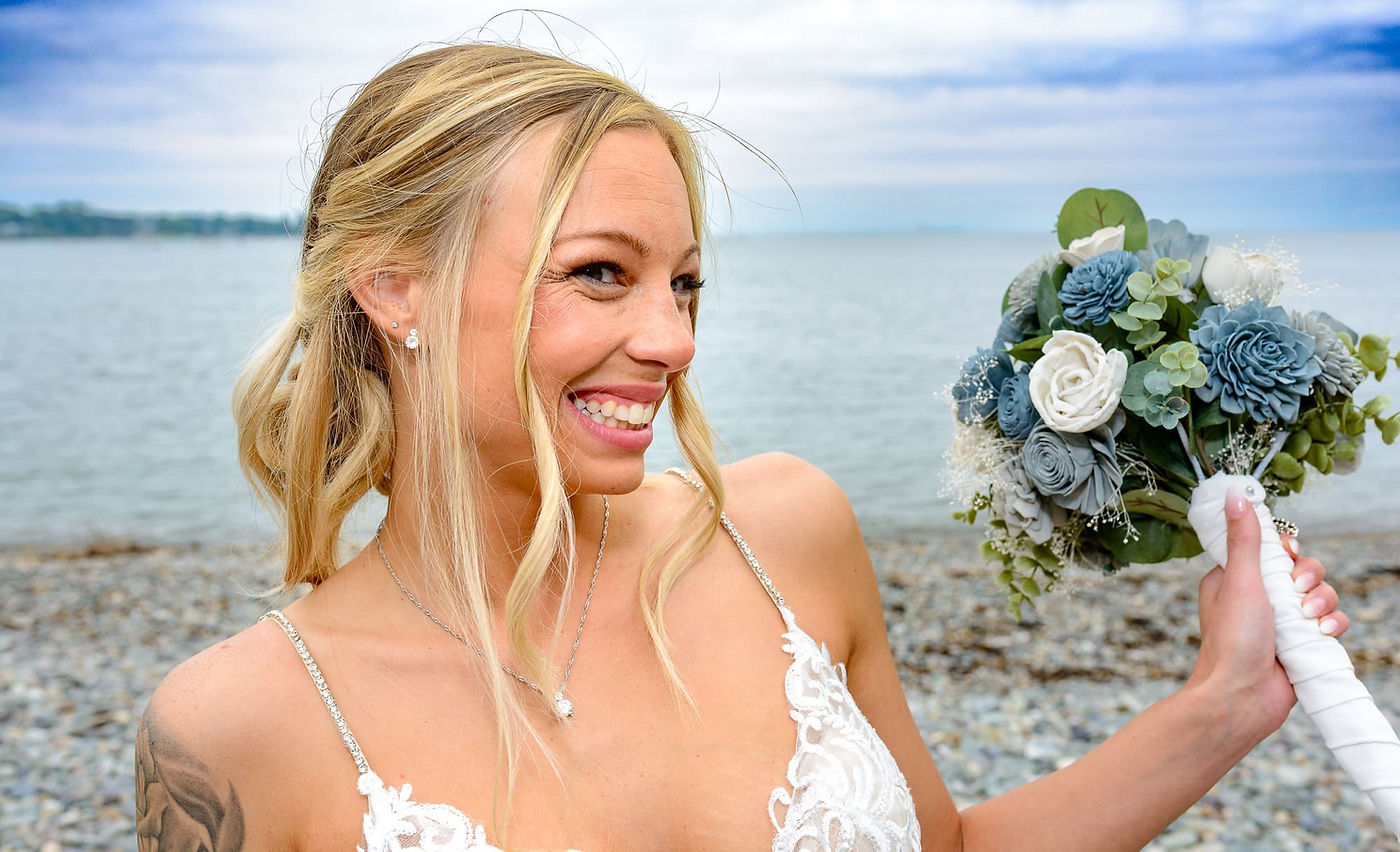 ocean-beach-wedding-bride-poses-with-cheesy-smile.jpg