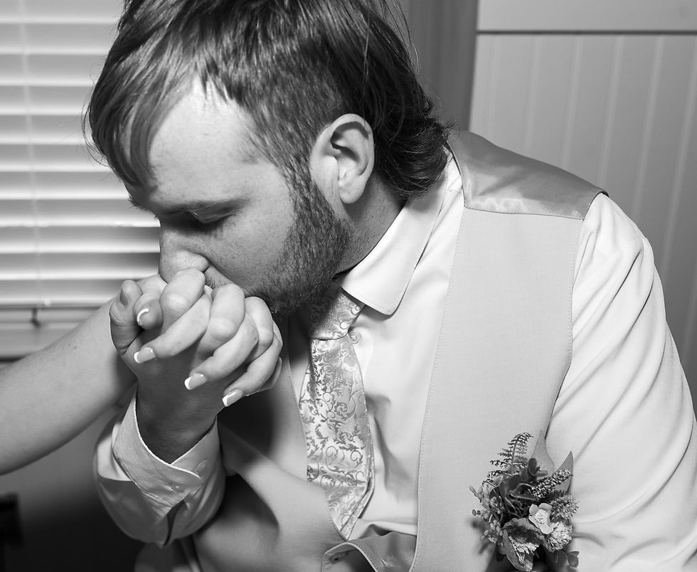 groom-kissing-brides-hand-in-black-and-white.JPG