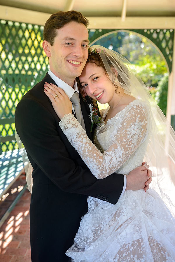 bride-and-groom-posing-in-a-gazebo-bride-in-amazing-dress-color.JPG
