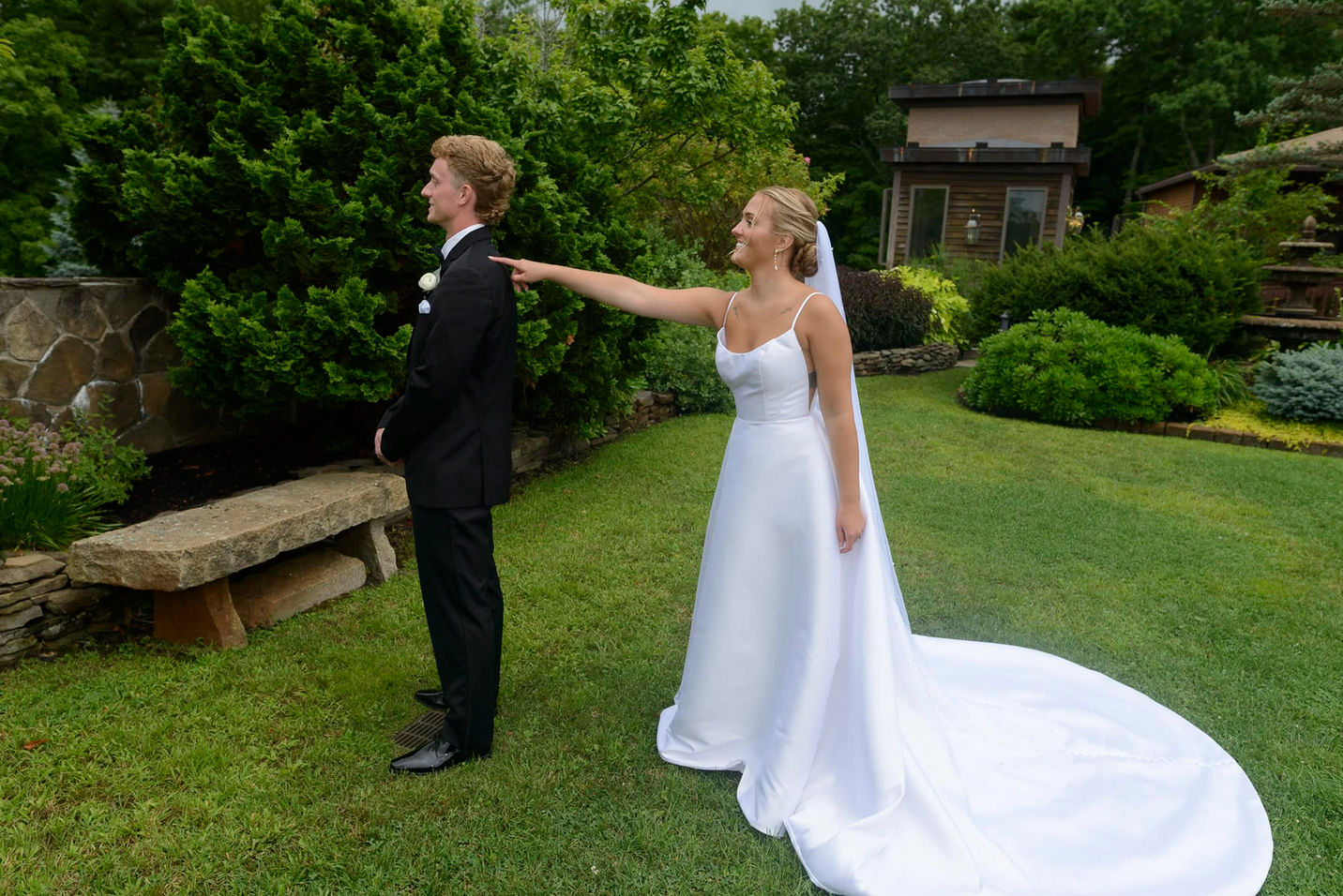 Bride tapping groom on shoulder during first look.