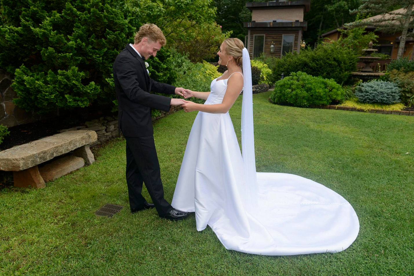 Bride and groom smiling during first look in garden.
