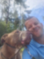 Pet care specialist with a smiling dog outdoors.