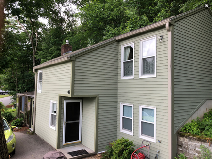 after photo of damaged siding that has been expertly repaired and then painted green.