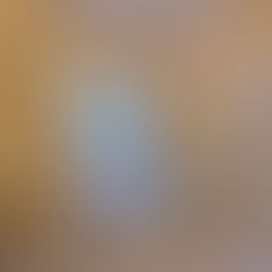 Elegant bathroom with a marble tub, hexagonal floor tiles, and a chandelier. Yellow walls and white shutters add a bright, classic feel.