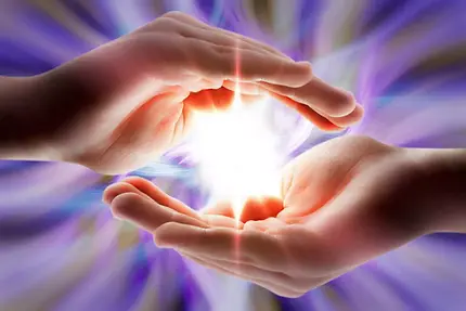 a single hand in the purple background holdin light