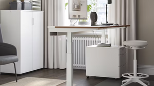 a standing desk with a computer on top of it in a room .