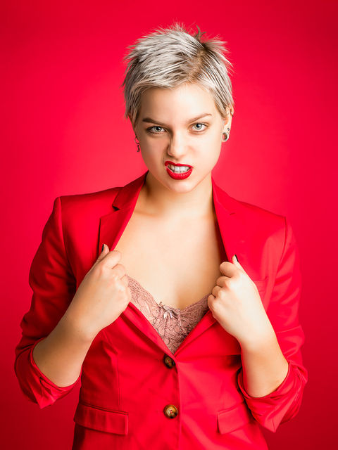 Dame poseert staand in rood jasje 