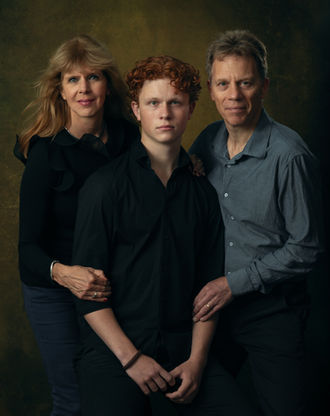Vader en moeder poseren staand met zoon
