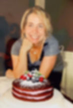 A woman behind a 3-layer Chocolate-raspberry cake