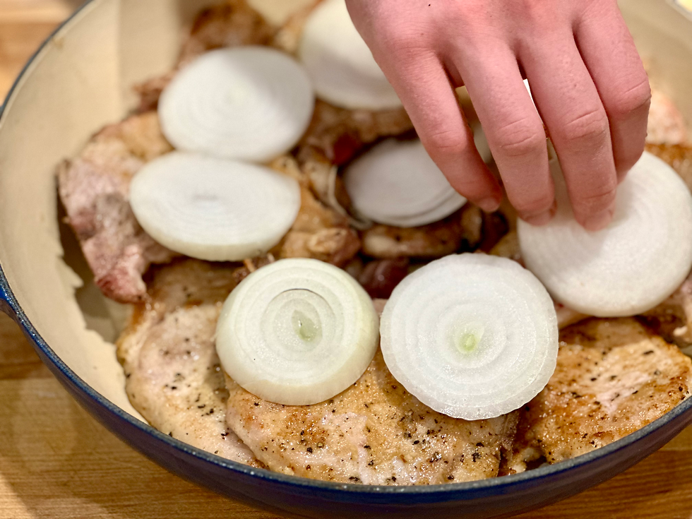 putting onions on top of the pork chops