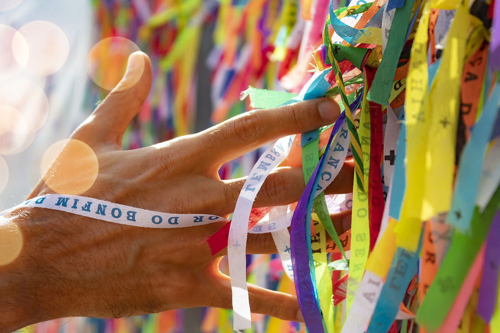 uma mão passando por fitinhas de Bonfim