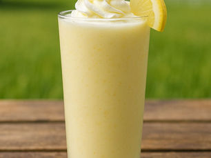 a tall glass of protein frosted lemonade sitting on a table outside