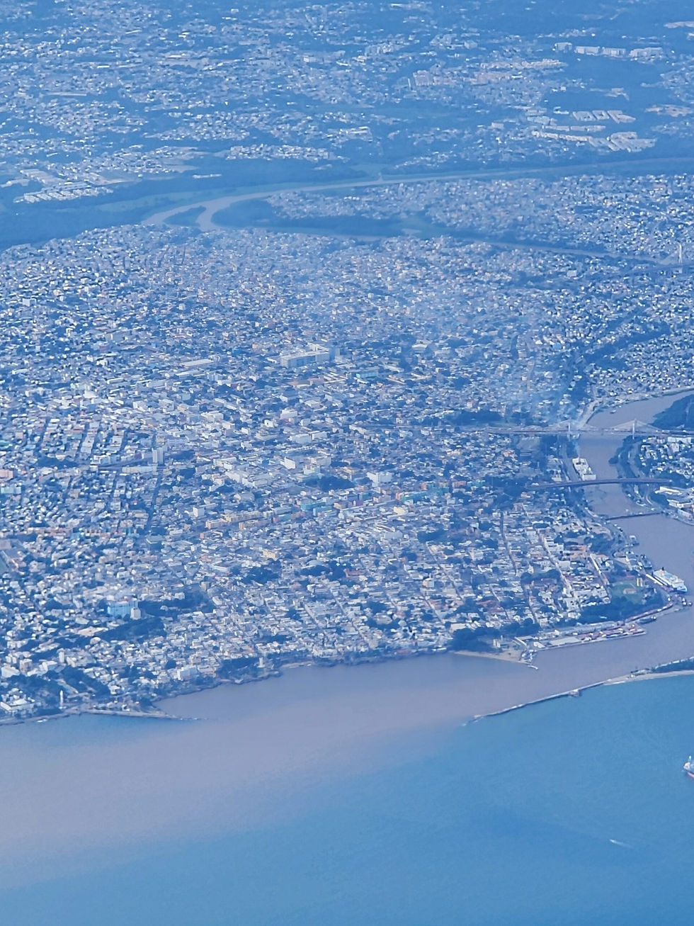 Aerial view of Santo Domingo, Dominican Republic, showing the city, Ozama River, bridges, and Caribbean coastline.