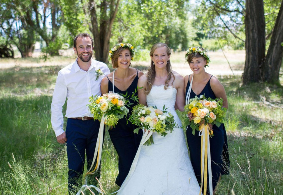 Hannah and Phil's January Wedding. Bride, groom and two bridesmaids stand in a wooded area holding beautiful bridal bouquets and wearing flower wreaths.