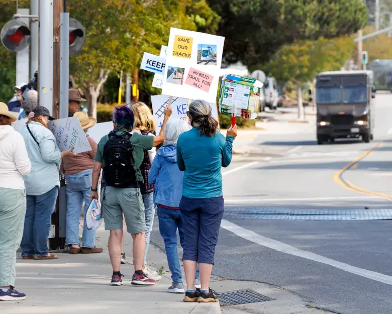 Rail supporters wave signs along 17th Avenue. Credit: Kevin Painchaud / Lookout Santa Cruz