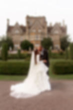 "Bride and groom share a golden hour kiss in the gardens of Tortworth Court, surrounded by lush greenery.