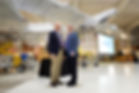Jim Anderson and John Langford standing together in an airplane hangar.