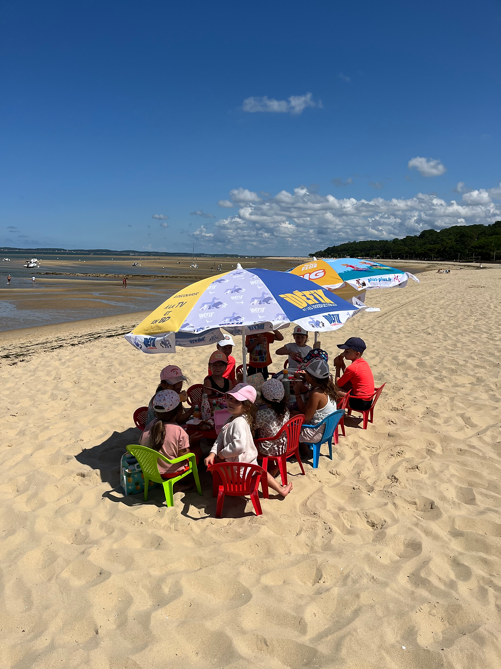 Vue panoramique au niveau des pieds sur la plage du bassin d'Arcachon avec des enfants jouant dans le sable