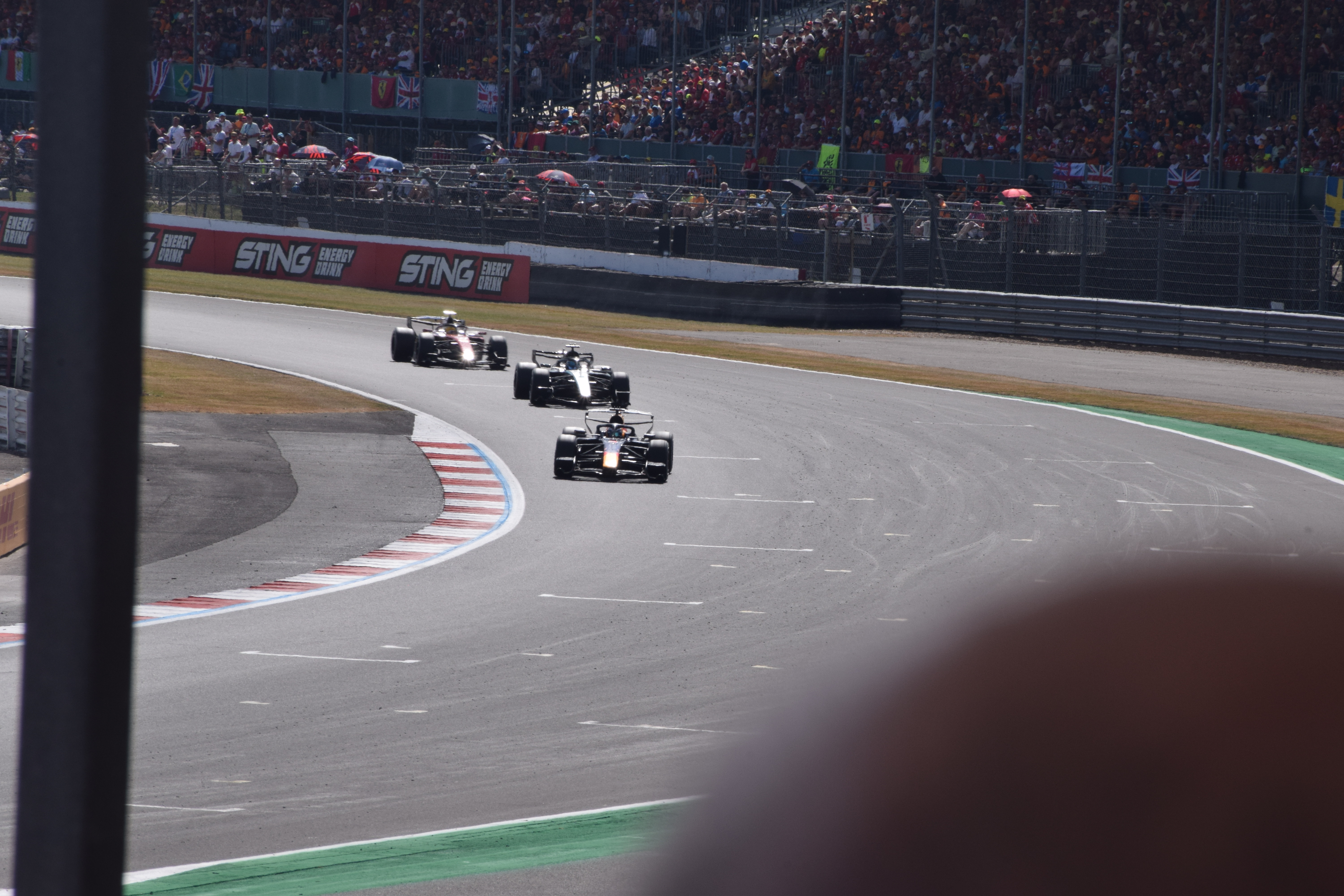 Red Bull, Mercedes and Ferrari Formula 1 cars racing together at the 2026 British Grand Prix