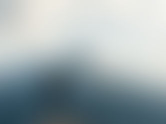 A man looks up at a high mountain in front of him