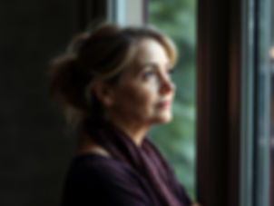 A women stares thoughtfully out of the window