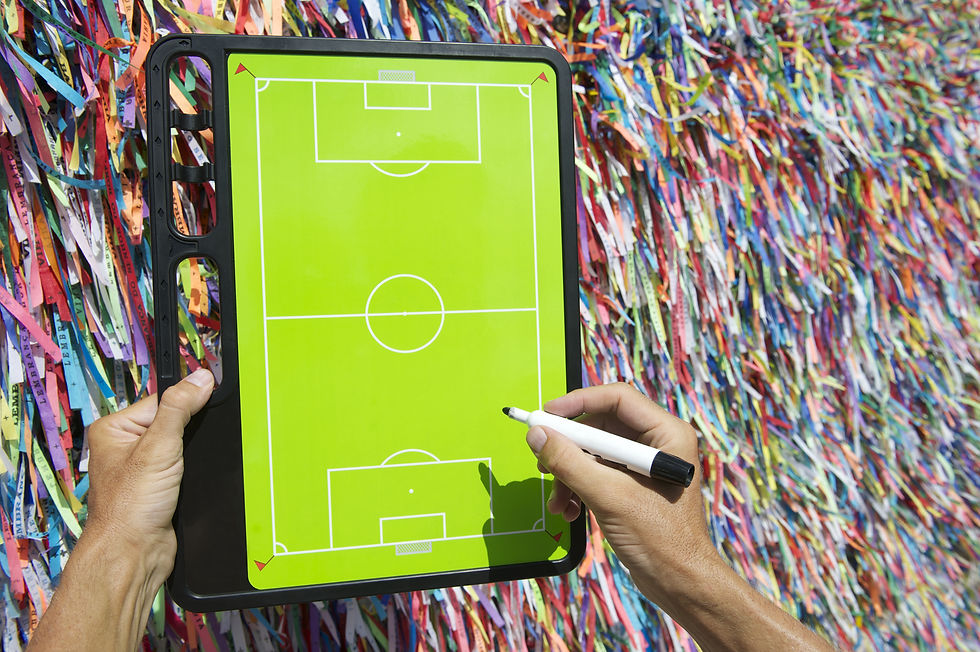 Hands writing on football tactics board in front of Brazilian wish ribbons in Salvador Bah