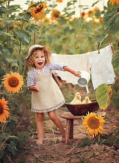 Enfant entouré de tournesols, explorant la nature dans le cadre des activités de l'association partenaire de la micro-crèche