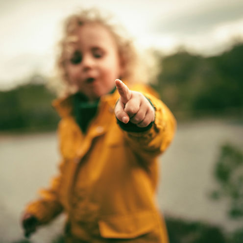 Enfant montrant du doigt en plein air, représentant l'approche nature et bien-être de la micro-crèche bien-être et nature