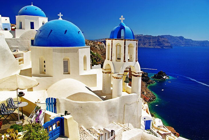 White buildings with blue domes overlook the deep blue sea in Santorini, Greece.