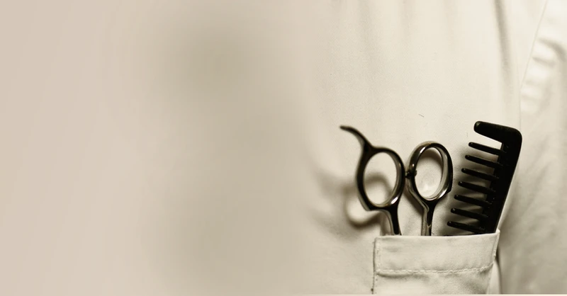 student learning scissor work from barbering teacher