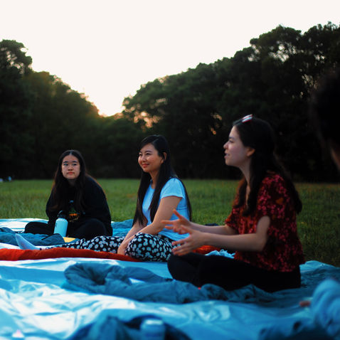 Co-founder Sophie Klimcak speaks to the group while co-founder Shasha Du and a teenage girl listen.