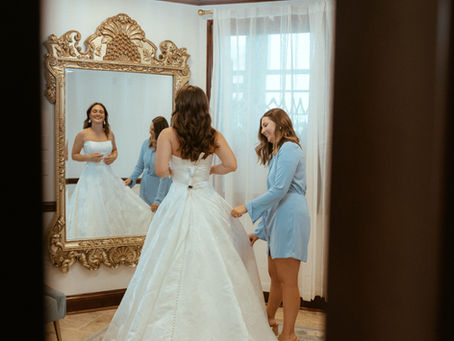 Bride smiling in a wedding gown while her family cheers during a bridal appointment at Baytowne Bridal