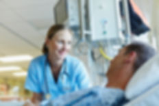 Licensed nurse helping patient in a hospital bed.