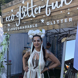 Sophie posing in front of eco glitter fun biodegradable glitter station at festival