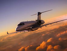 Pre-owned private jet cruising above the clouds at sunset