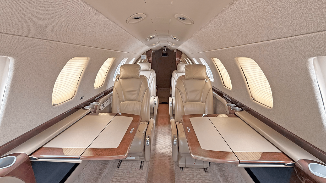 Cabine club do Citation CJ3 com mesas executivas abertas