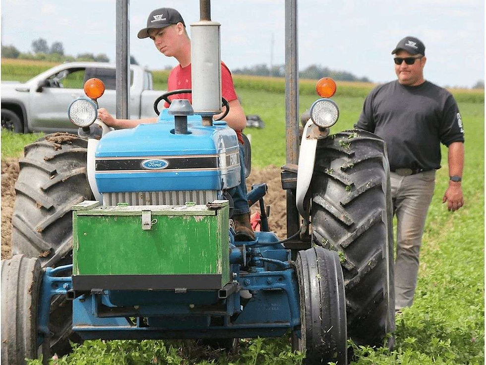 Alvinston’s Patrick Sanders, right, coaches his nephew, Cameron Vos, at the Lambton Plowing Match Saturday in Plympton-Wyoming. (Tyler Kula/The Observer)