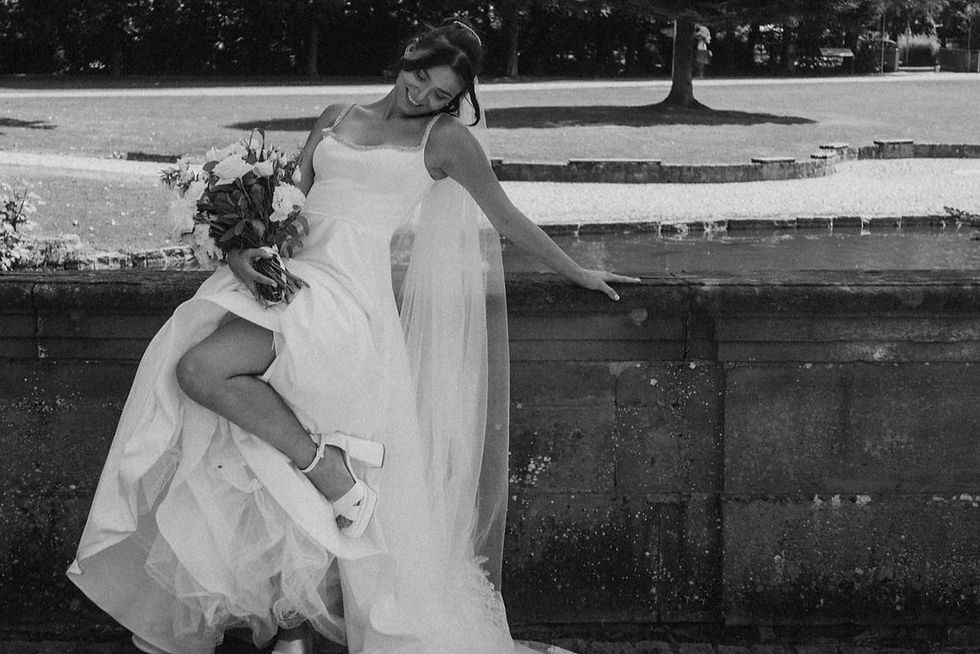 Braut im Brautkleid Abigail von Wona Concept mit Blumen in der Hand beim Hochzeitstag