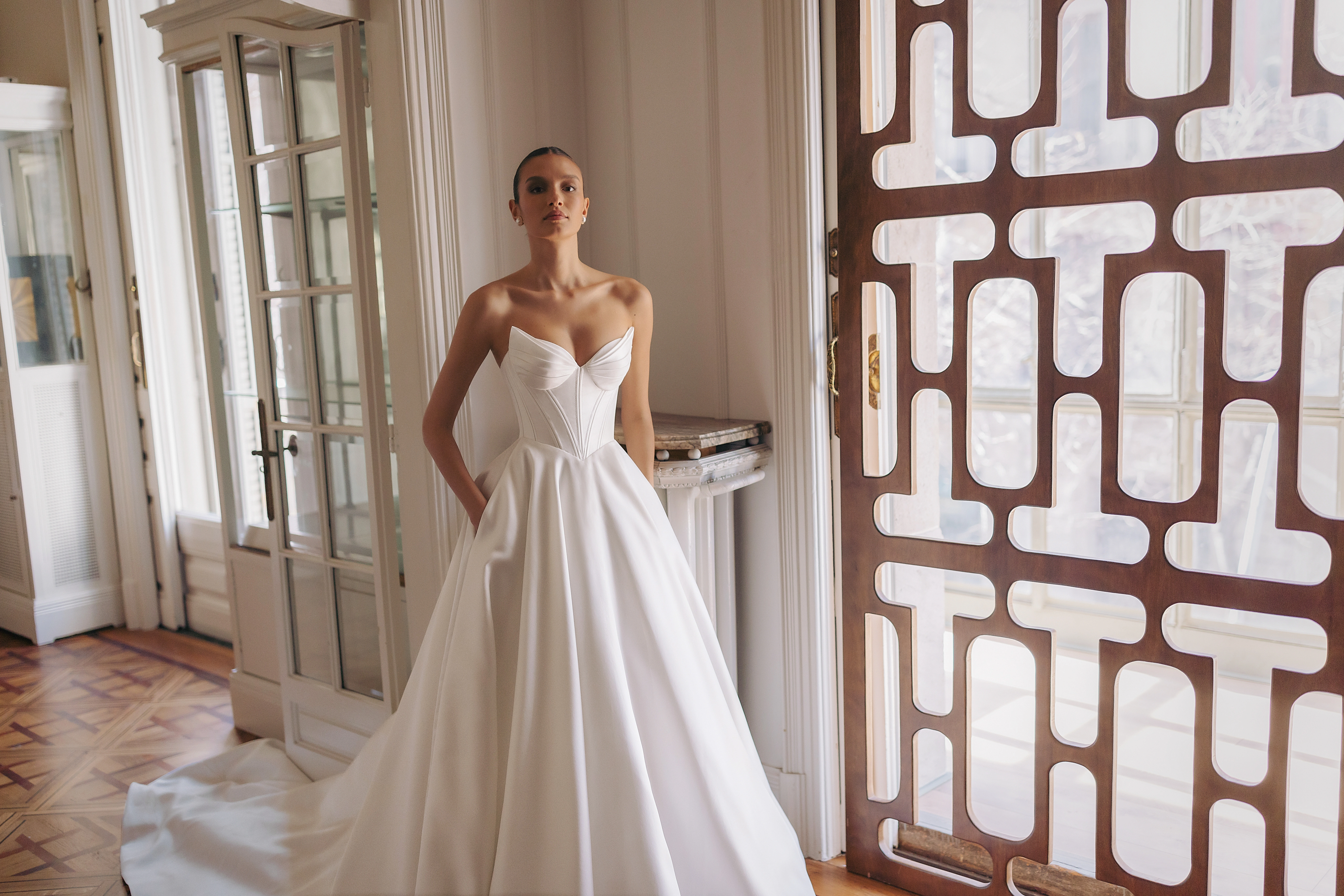 Brautkleid mit tiefem V-Ausschnitt, zarten Spaghettiträgern und weitem Tüllrock – romantisch-leichter Look mit einem Hauch von Ballettästhetik, perfekt für Sommerhochzeiten.