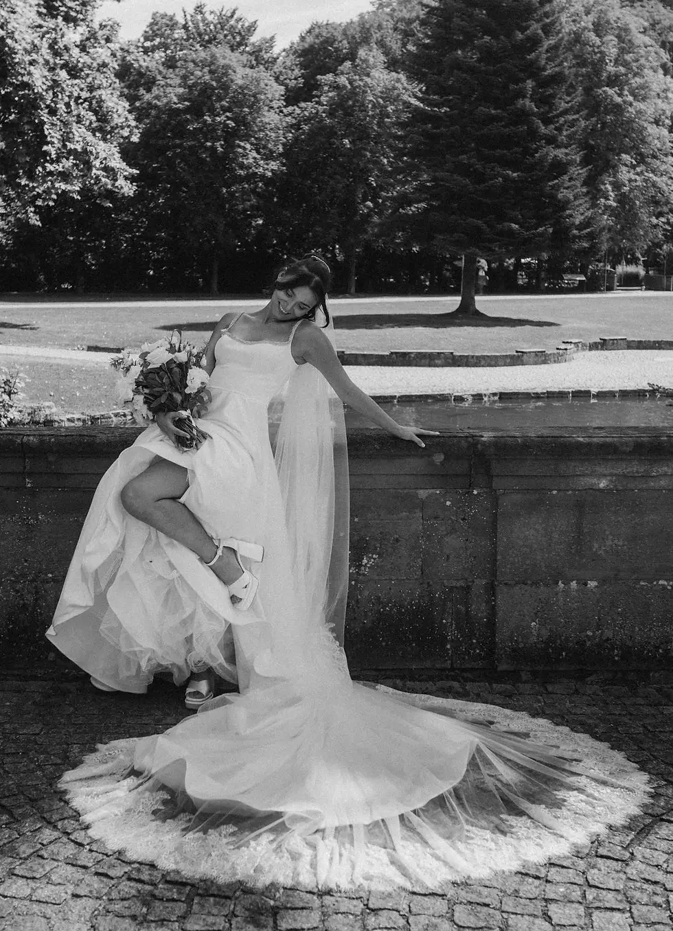 Braut im Brautkleid Abigail von Wona Concept mit Blumen in der Hand beim Hochzeitstag